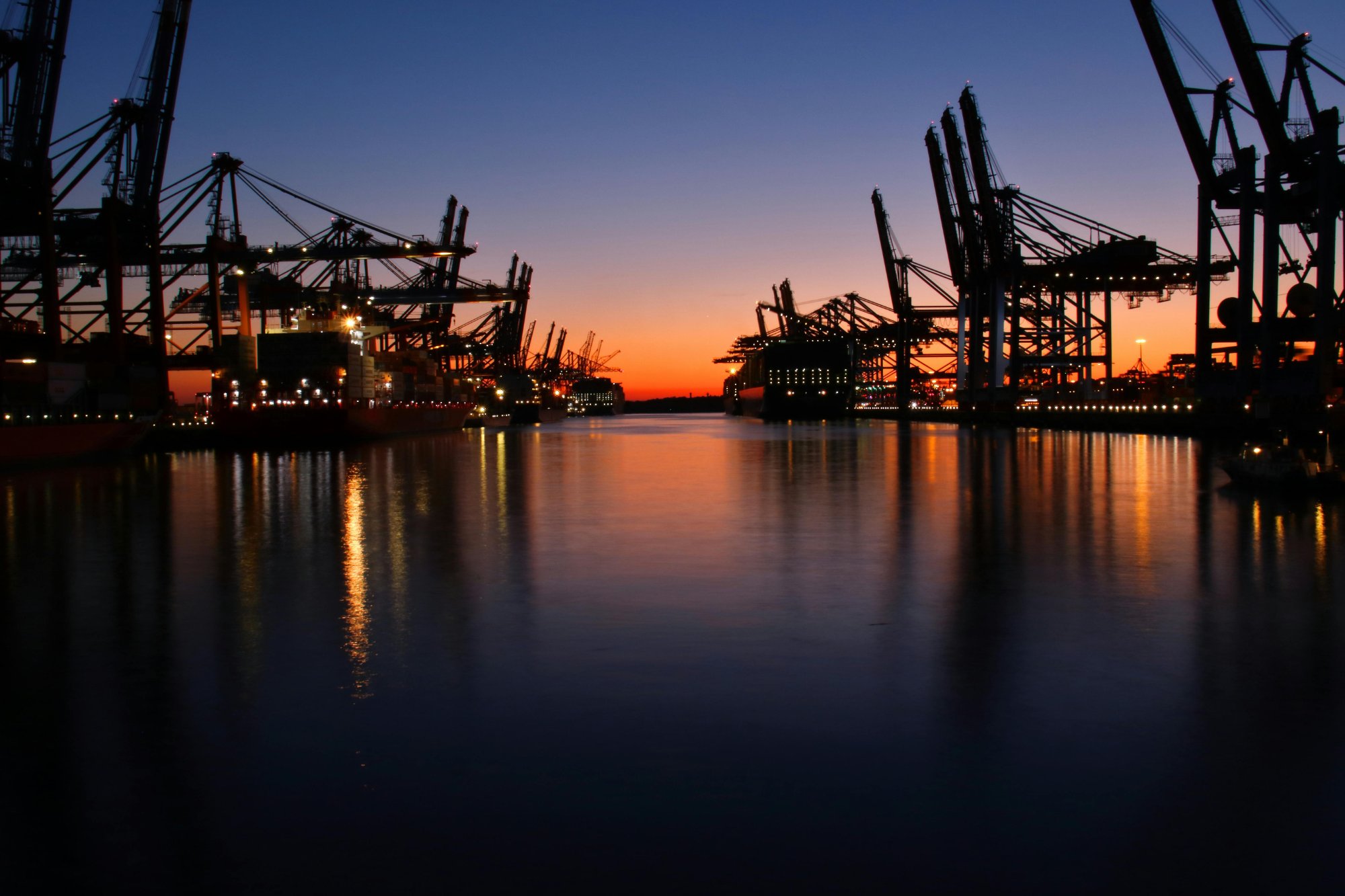 Port at sunset with crane silhouettes